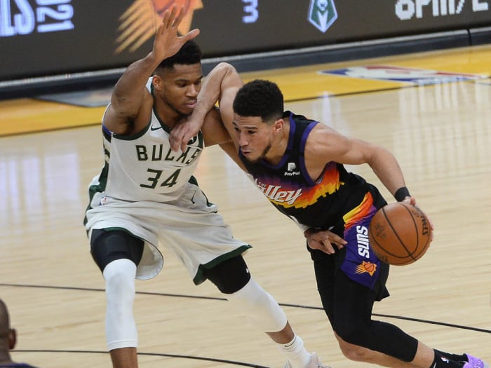Phoenix Suns guard Devin Booker (1) moves the ball against Milwaukee Bucks forward Giannis Antetokounmpo (34) during the second half in game two of the 2021 NBA Finals at Phoenix Suns Arena.